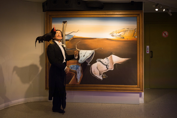 Estátua de cera de Salvador Dalí, artista surrealista, em frente à obra do pintor  “A persistência da memória”.