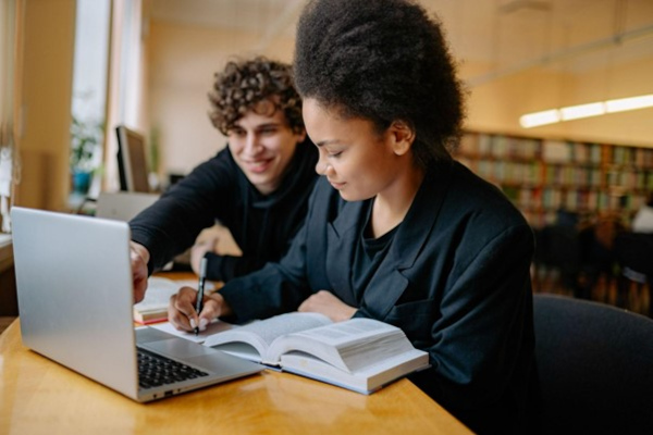 Pessoas utilizando notebook e recursos de inteligência artificial para aprimorar os estudos.